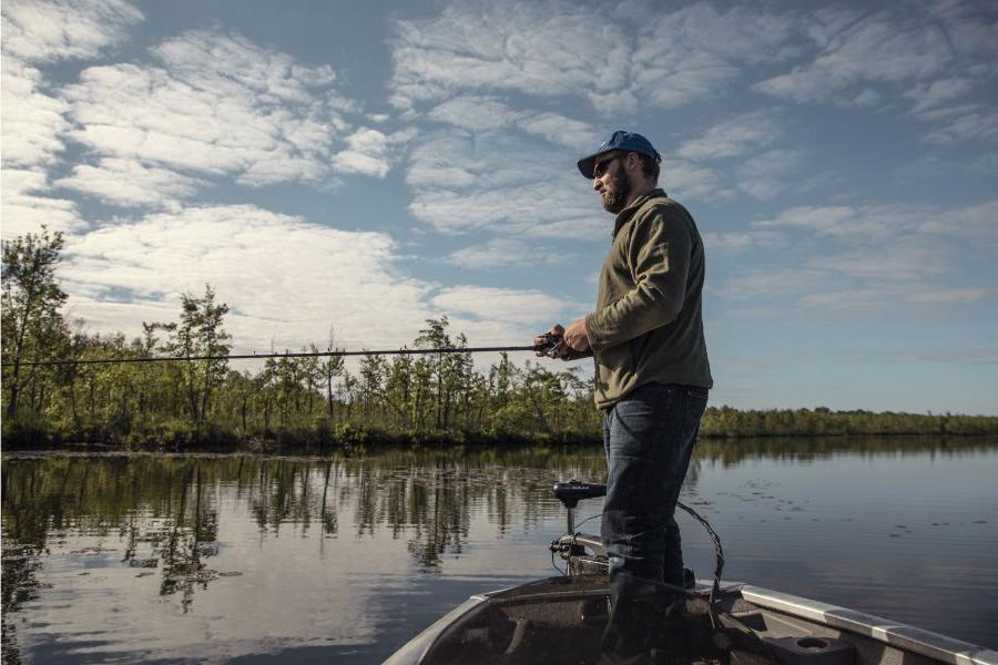 man standing on a boat fishing